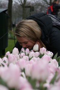 Close-up of young woman with pink flowers at park
