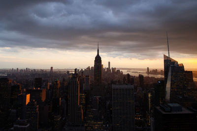 Buildings in city against cloudy sky