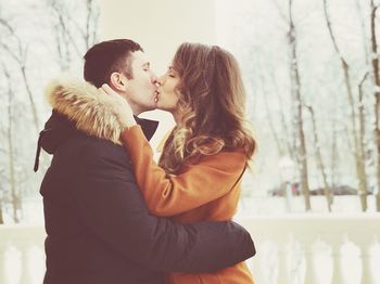 Side view of young couple kissing in winter