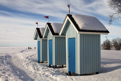 Lifeguard hut on snow covered field against sky