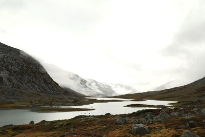 Scenic view of lake and mountains against sky