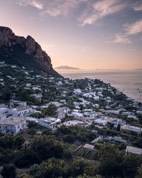 Aerial view of townscape by sea against sky