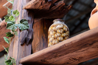 Pickled garlic in a large glass jar on a wooden shelf. tasty pickled garlic