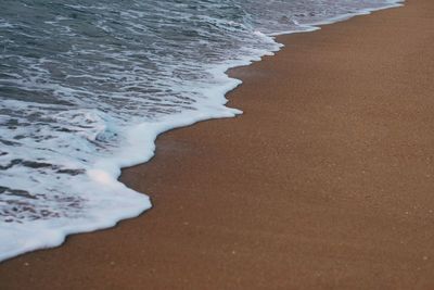 High angle view of water meeting the sand on beach