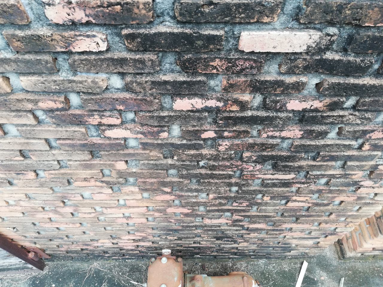 LOW SECTION OF WOMAN STANDING AGAINST BRICK WALL