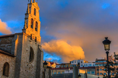 Low angle view of clock tower against cloudy sky