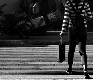 Low section of man walking on road