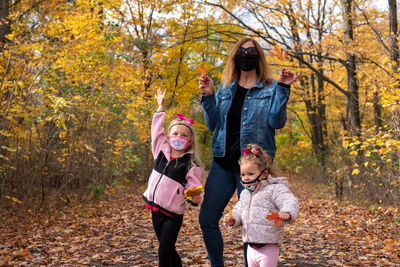 Full length of women standing on street during autumn