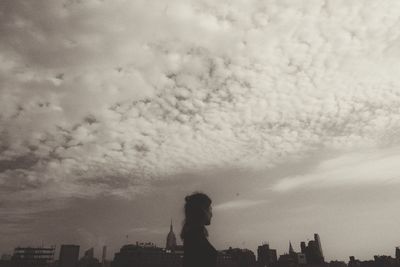 Silhouette of buildings against cloudy sky