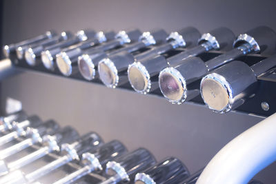 Close-up of dumbbells on racks at health club