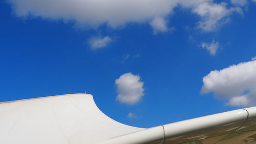 Low angle view of airplane against blue sky