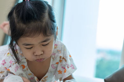 Close-up portrait of cute girl looking down