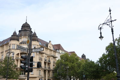 Low angle view of buildings and trees against sky