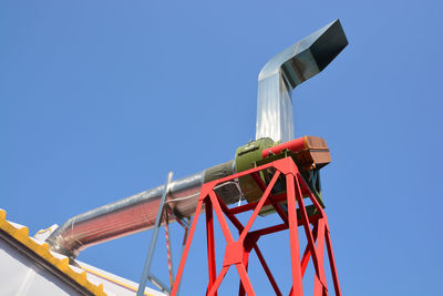 Low angle view of traditional windmill against clear blue sky