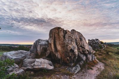 Rock formations on shore against sky