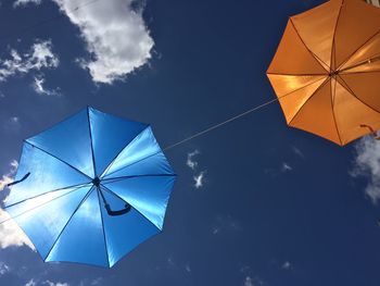 Low angle view of umbrella against blue sky