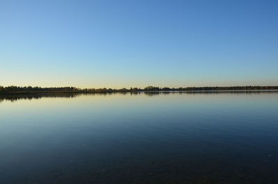 Scenic view of lake against clear blue sky