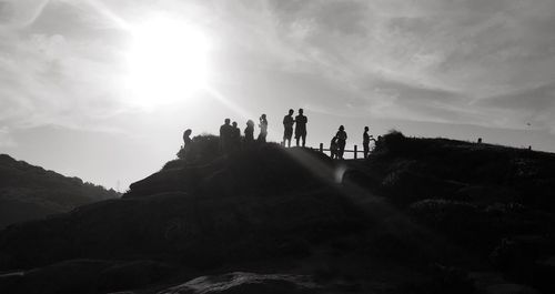 Silhouette people standing on landscape against the sky