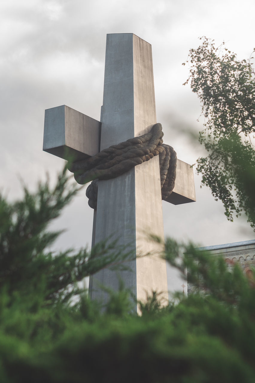 sky, nature, architecture, plant, cloud, tree, no people, cross, monument, outdoors, religion, built structure, grave, day, memorial, cemetery, belief, low angle view