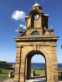 Low angle view of clock tower against blue sky