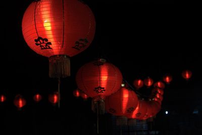 Low angle view of illuminated lanterns hanging at night