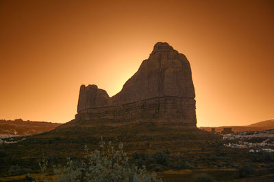 Rock formation against clear sky during sunset