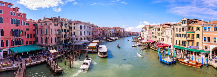 Panoramic view of boats in canal amidst buildings in city