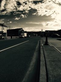 Empty road against cloudy sky