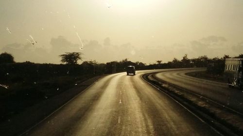 Man on road against sky during sunset