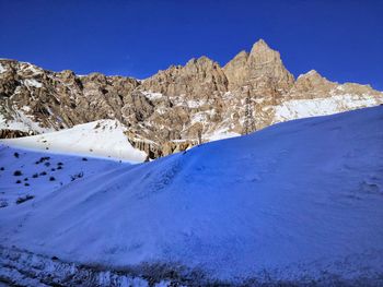 Scenic view of snowcapped mountains against clear blue sky