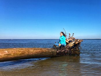 Man surfing in sea against clear blue sky