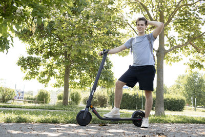 Portrait of young man exercising on field