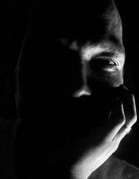 Close-up portrait of young man against black background