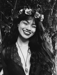 Portrait of smiling young woman against plants