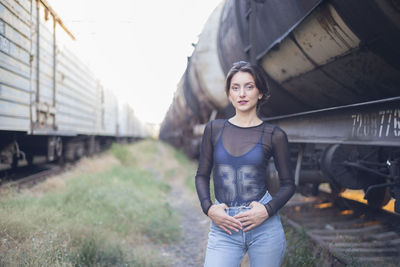 Portrait of young woman standing at shunting yard