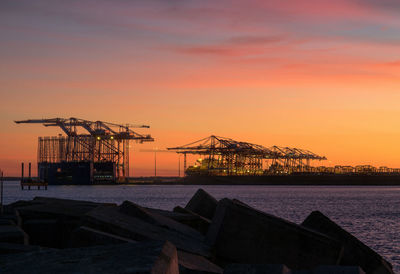 Silhouette pier by sea against sky during sunset
