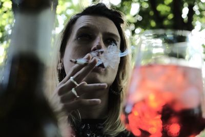 Portrait of woman holding glass outdoors