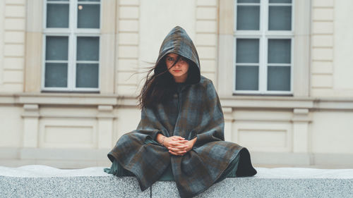 Portrait of young woman in front of building