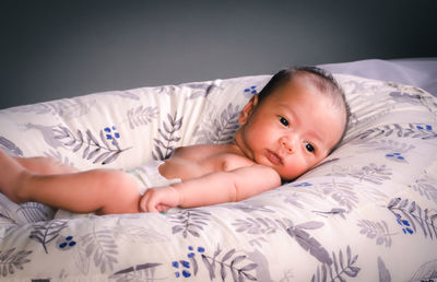 Portrait of cute boy lying on bed