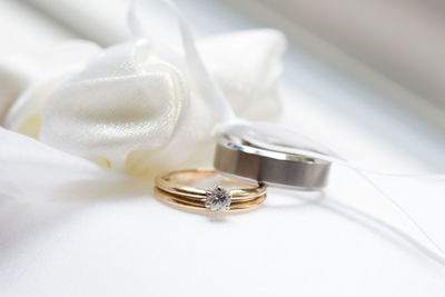 Close-up of wedding rings on white table