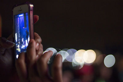 Close-up of hand holding smart phone at night