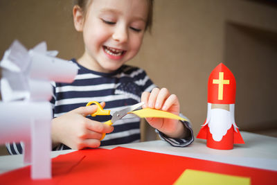 Midsection of boy holding toy while sitting on table