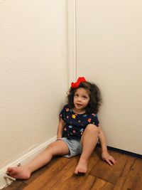 Portrait of young woman sitting on floor at home