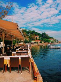 Chairs and tables at restaurant against sky