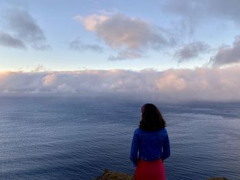 Rear view of woman looking at sea against sky