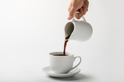 Hand pouring coffee in cup