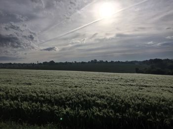 Scenic view of field against cloudy sky