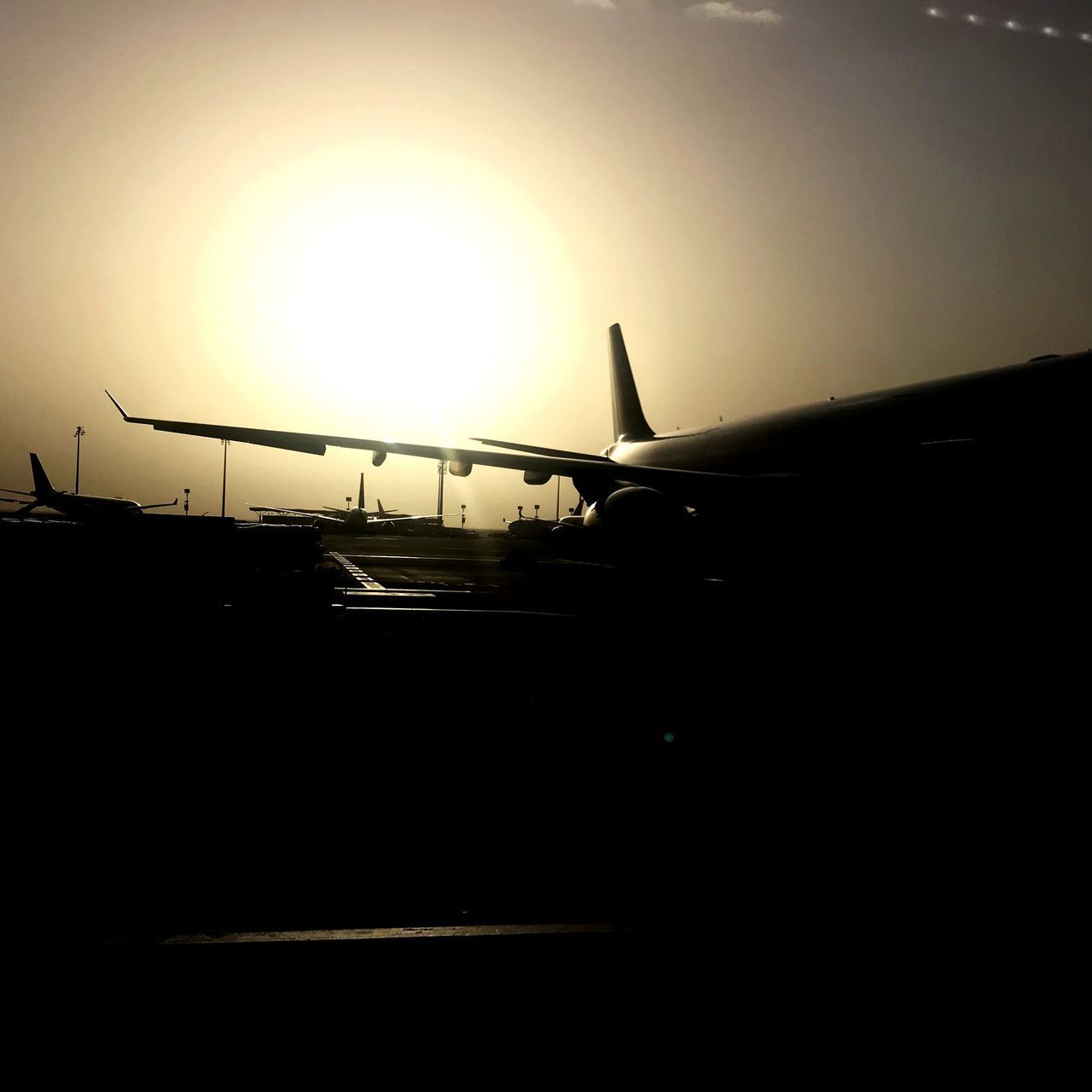 SILHOUETTE AIRPLANE ON RUNWAY AGAINST SKY