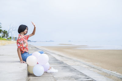 Asian young girl enjoy time playing balloone at the beach.