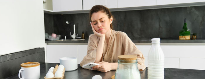 Portrait of young woman sitting on table